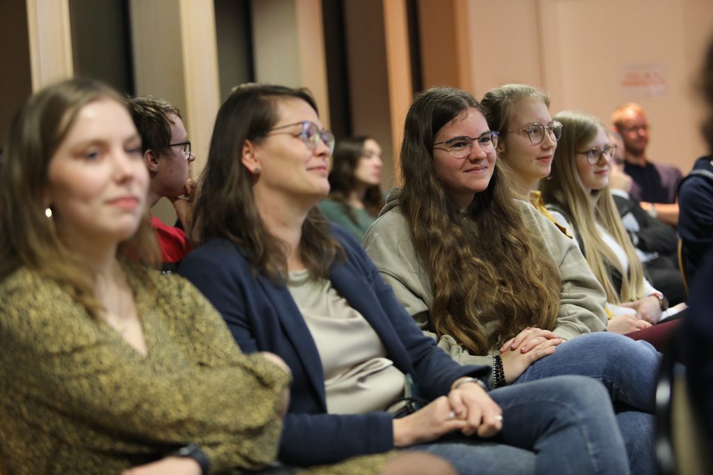 Junge Frauen sitzen nebeneinander und folgen der Podiums-Diskussion mit den Politiker*innen aus ihrem Landkreis